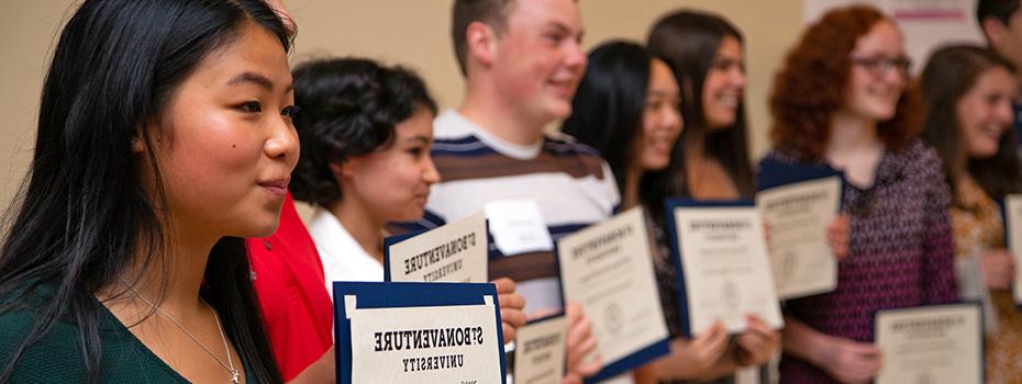 High school STEM students holding certificates